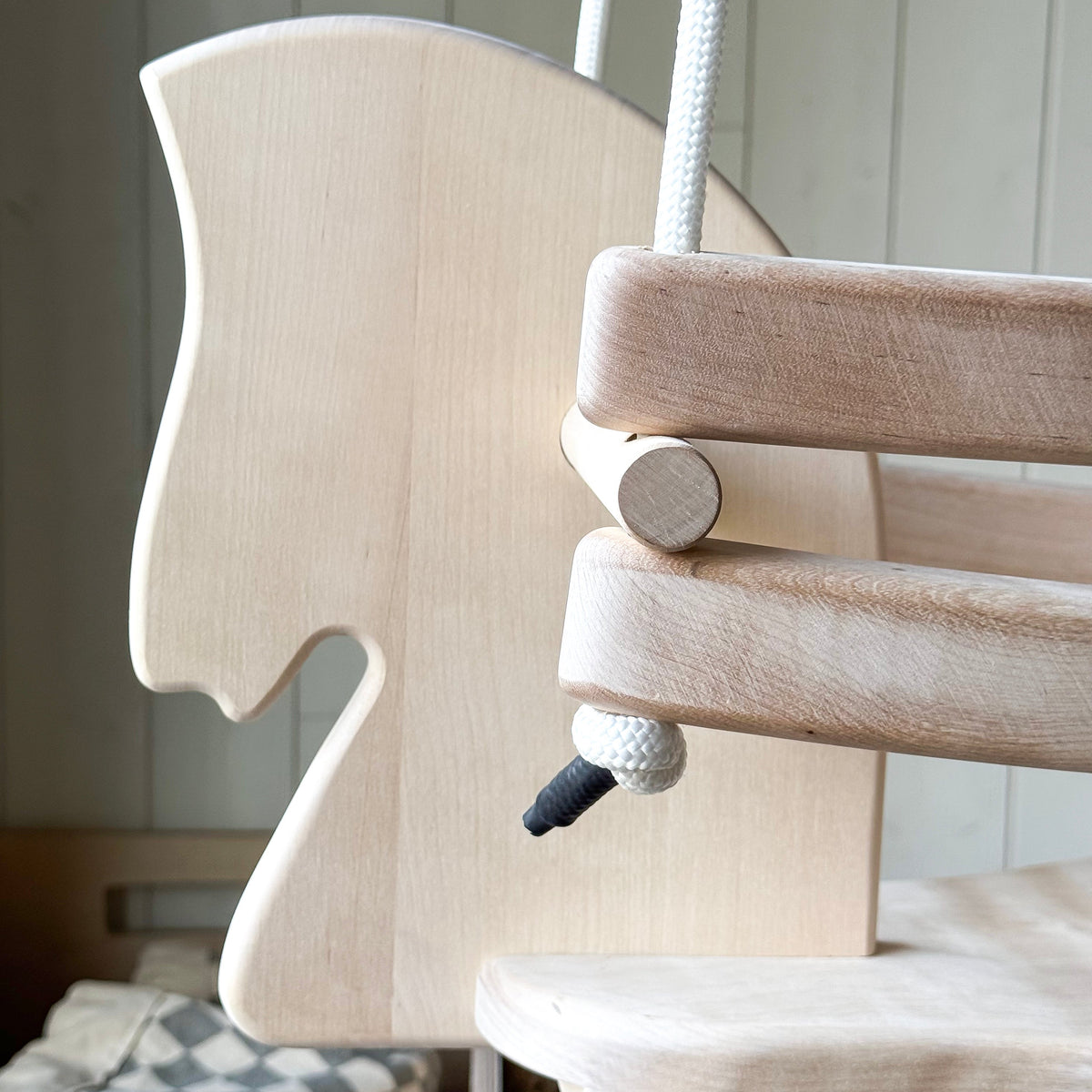 Wooden baby swing with a neutral background