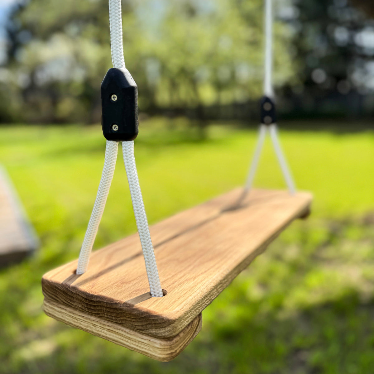 Wooden swing with white ropes in a park setting