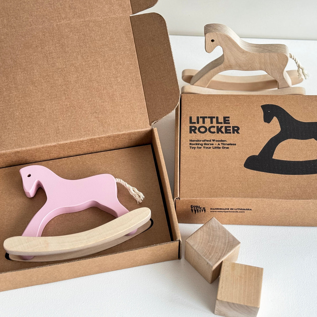 Wooden rocking horse toy in an open cardboard box with 'Little Rocker' packaging on a white background.
