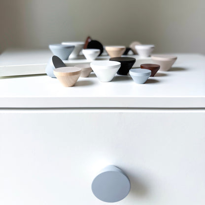 Collection of wooden knobs on a white surface with a neutral background