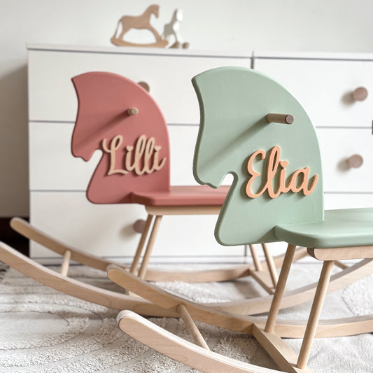 Two colorful rocking horses with names 'Lilli' and 'Elia' on a white background.